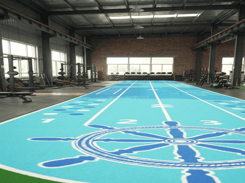 Commercial gym layout showing turf transition to rubber flooring